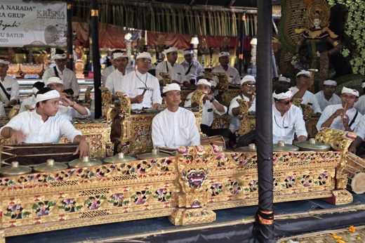 Traditional Balinese gamelan musicians performing at a temple ceremony in Ubud, Bali, wearing ceremonial white attire. 