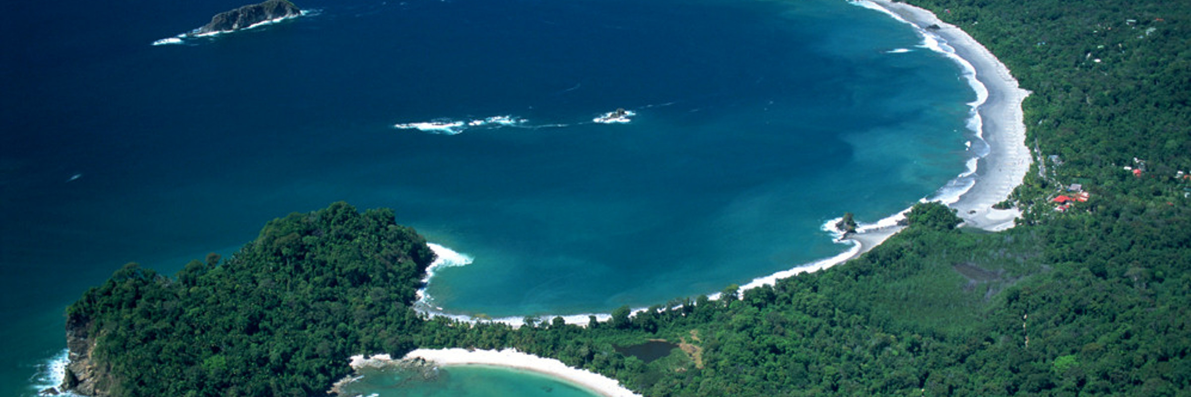 A breathtaking aerial shows Manuel Antonio's twin beaches and lush rainforest hugging the Pacific coast.  