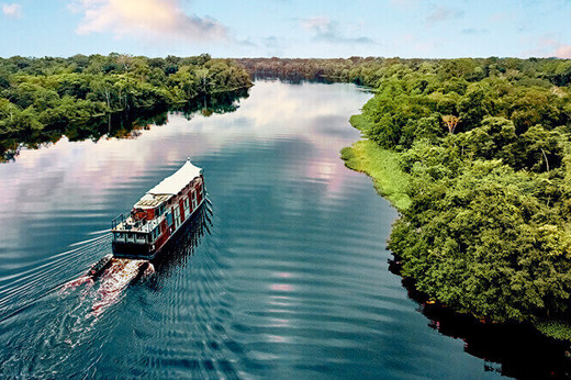 The Aria Amazon glides through emerald rainforest, offering an unforgettable jungle cruise in Peru. 