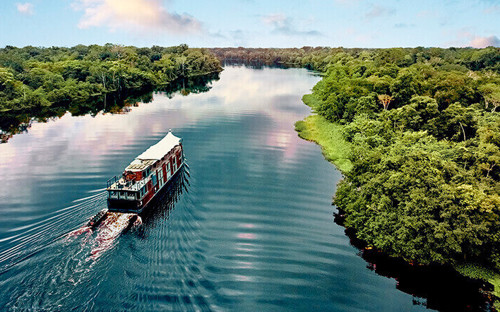 The Aria Amazon glides through emerald rainforest, offering an unforgettable jungle cruise in Peru. 