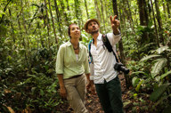 Visitors on a guided trek through the Peruvian Amazon rainforest, learning about local wildlife and plants. 