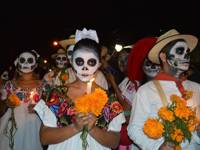 Traditional Day of the Dead parade with face paint, marigolds, and colourful attire honoring Mexican ancestors. 