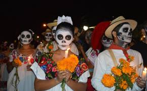 Traditional Day of the Dead parade with face paint, marigolds, and colourful attire honoring Mexican ancestors. 