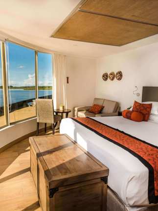 Expedition cruise in the stunning corner suite with expansive views of the rainforest