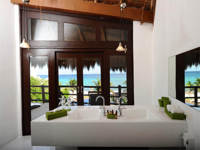 Luxury hotel suite in Riviera Maya, Mexico, with panoramic window and ocean views. 