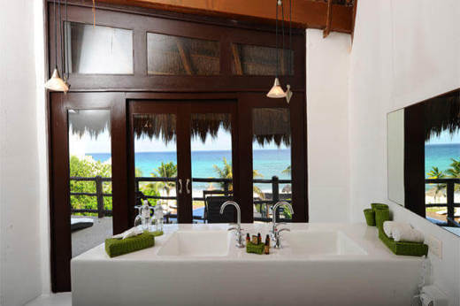 Luxury hotel suite in Riviera Maya, Mexico, with panoramic window and ocean views. 