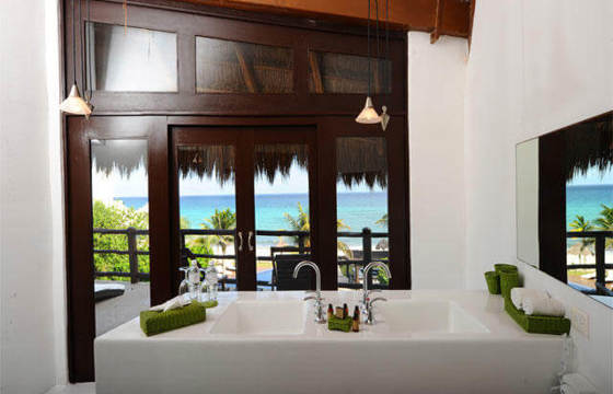 Luxury hotel suite in Riviera Maya, Mexico, with panoramic window and ocean views. 