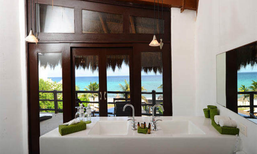Luxury hotel suite in Riviera Maya, Mexico, with panoramic window and ocean views. 