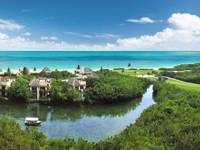 Aerial view of Fairmont Mayakoba Resort in Riviera Maya showing mangroves, water canals, villas, and the Caribbean Sea. 