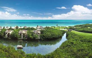 Aerial view of Fairmont Mayakoba Resort in Riviera Maya showing mangroves, water canals, villas, and the Caribbean Sea. 