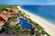 Aerial view of the Large swimming pool at Zoetry Paraiso de la Bonita Resort, Yucatan, with lush gardens and beachfront location. 