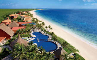 Aerial view of the Large swimming pool at Zoetry Paraiso de la Bonita Resort, Yucatan, with lush gardens and beachfront location. 