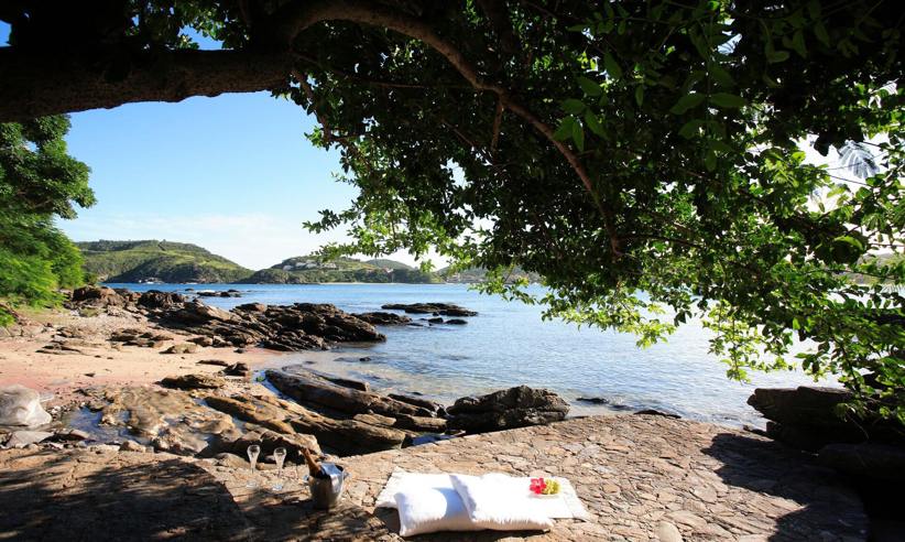 Shaded rocky beach at Insolito Hotel in Buzios, Brazil , offering a peaceful and scenic seaside retreat. 