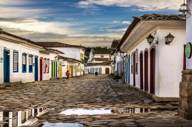 Cobbled street in Paraty's historic old town lined with colourful colonial buildings after rain, reflecting Brazil's charm. 