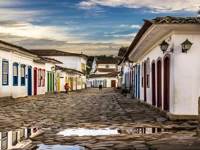 Cobbled street in Paraty's historic old town lined with colourful colonial buildings after rain, reflecting Brazil's charm. 