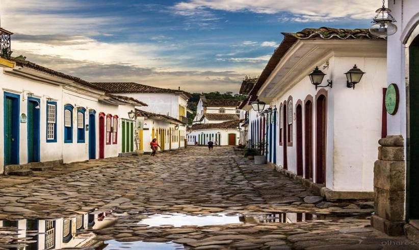 Cobbled street in Paraty's historic old town lined with colourful colonial buildings after rain, reflecting Brazil's charm. 