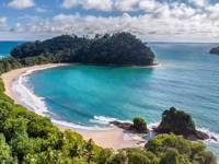 Crystal-clear waters and golden sands curve into a perfect bay at Manuel Antonio, Costa Rica. 