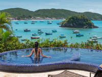 Infinity pool at Villa d'Este, Buzios, with panoramic views over Armacao Bay and anchored boats. 