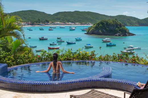 Infinity pool at Villa d'Este, Buzios, with panoramic views over Armacao Bay and anchored boats. 