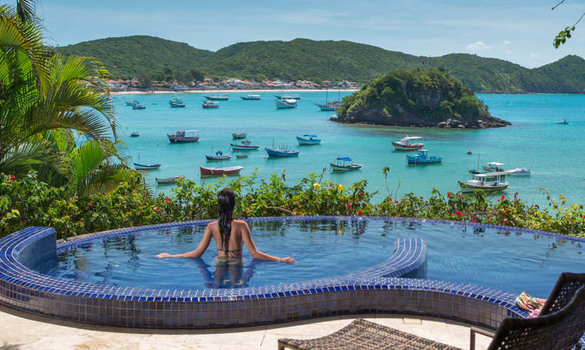 Infinity pool at Villa d'Este, Buzios, with panoramic views over Armacao Bay and anchored boats. 