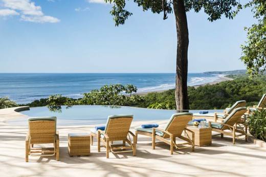 Lounge chairs line an infinity pool overlooking the Pacific, offering a tranquil setting at Lagarta Lodge. 