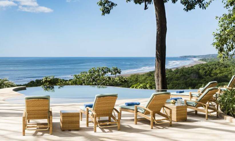 Lounge chairs line an infinity pool overlooking the Pacific, offering a tranquil setting at Lagarta Lodge. 