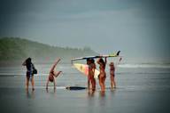 Tourists Surfers on the wide, tranquil beach of Playa Esterillos on Costa Rica's Pacific coast. 