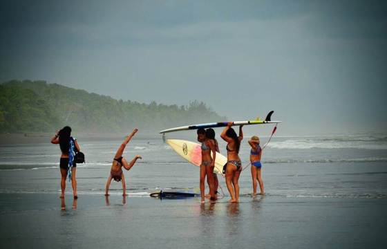 Tourists Surfers on the wide, tranquil beach of Playa Esterillos on Costa Rica's Pacific coast. 