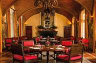Elegant colonial-style hotel dining room with red chairs, arched ceiling, and warm ambient lighting in Mexico. 