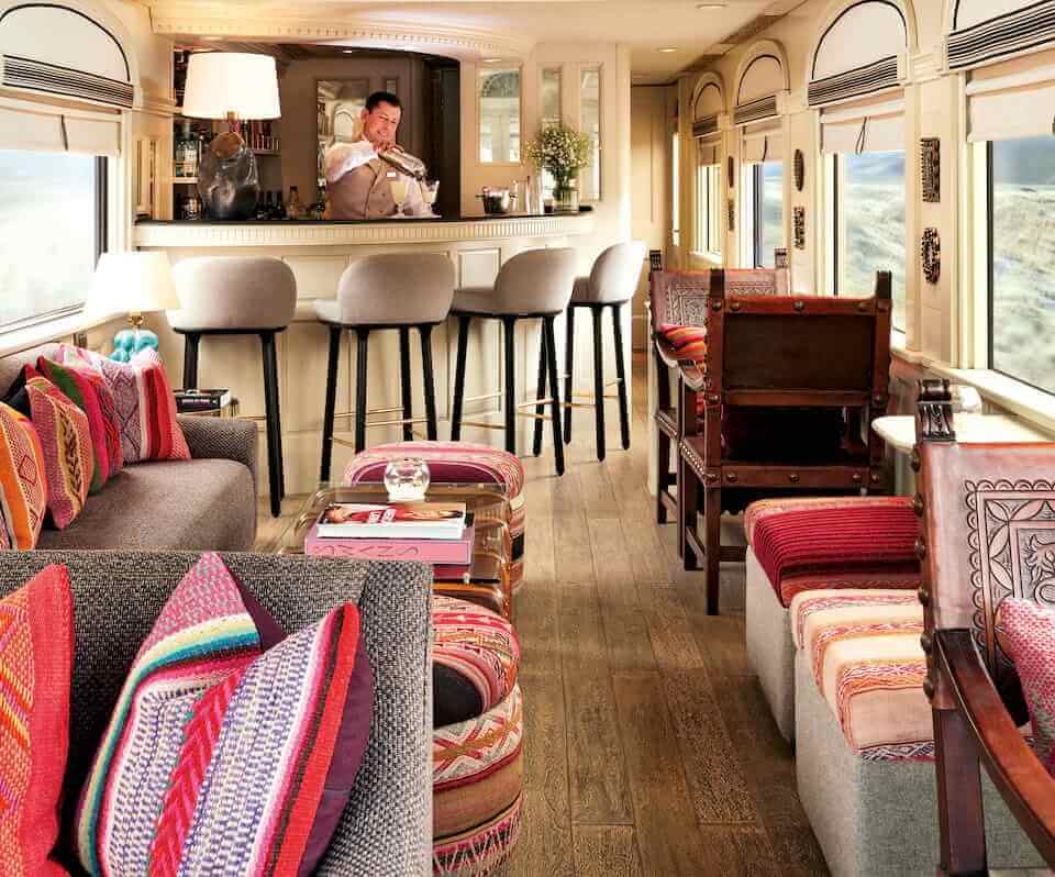 Colorful lounge car on the Belmond Andean Explorer, with bar and panoramic windows. 