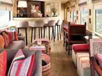 Colorful lounge car on the Belmond Andean Explorer, with bar and panoramic windows. 