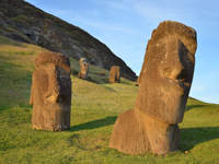 Ancient Moai statues partially buried on the grassy slopes of Rano Raraku, the volcanic quarry on Easter Island where these iconic figures were carved centuries ago. 