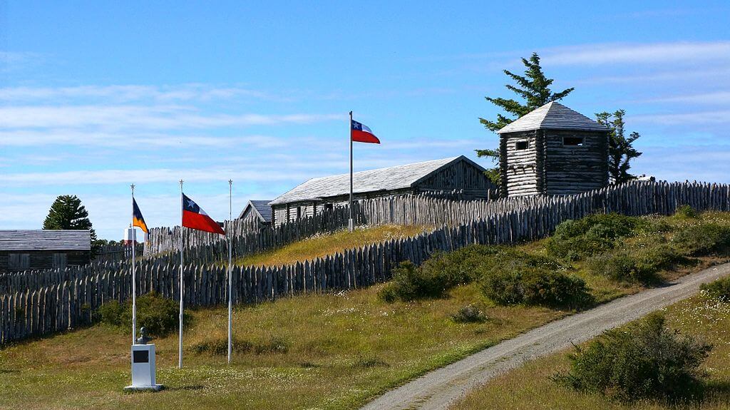 A reconstructed wooden fort with flags flying marks the historic site of Fort Bulnes near Puerto de Hambre southern Chile. 