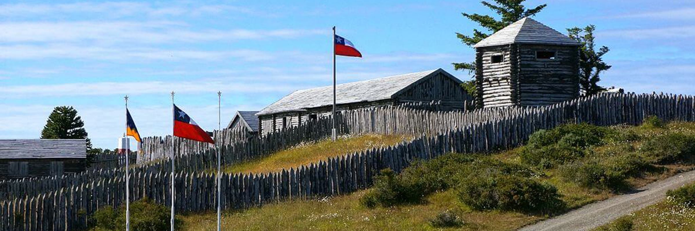 A reconstructed wooden fort with flags flying marks the historic site of Fort Bulnes near Puerto de Hambre southern Chile. 