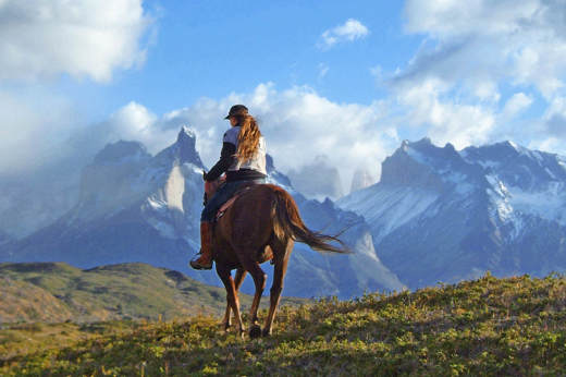 Horseback ride to Los Cuernos in Torres del Paine, with view of Patagonia peaks in Chilean national park. 