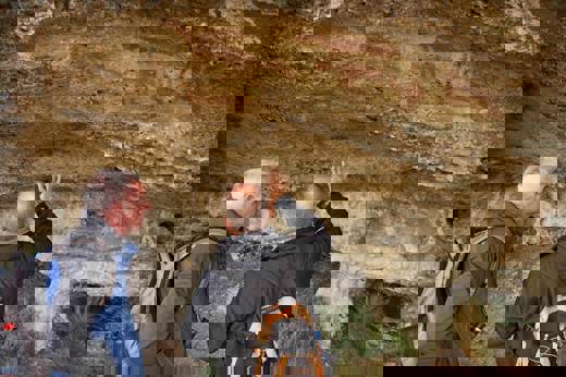 Two men examine ancient Aonikenk cave paintings in Patagonia on a cultural heritage hike near Torres del Paine, Chile. 
