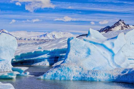 Vivid blue ice formations of Glacier Grey with snow-capped peaks in Torres del Paine National Park, Patagonia. 