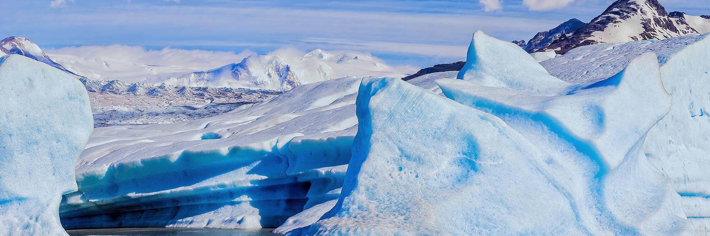 Vivid blue ice formations of Glacier Grey with snow-capped peaks in Torres del Paine National Park, Patagonia. 