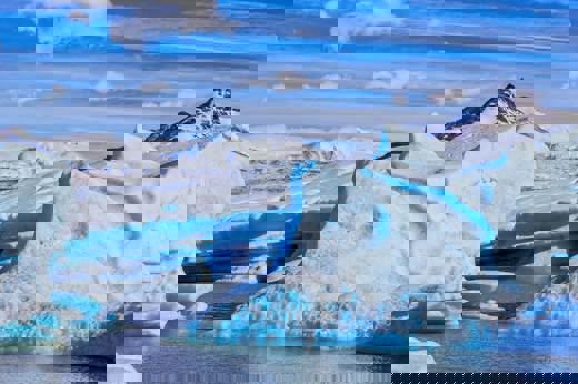 Vivid blue ice formations of Glacier Grey with snow-capped peaks in Torres del Paine National Park, Patagonia. 