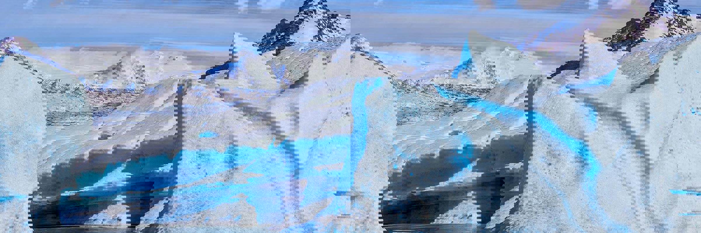 Vivid blue ice formations of Glacier Grey with snow-capped peaks in Torres del Paine National Park, Patagonia. 