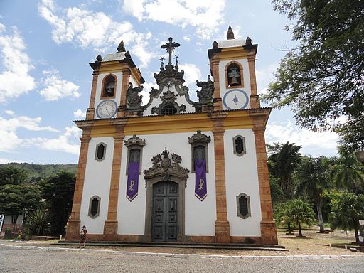 Colonial baroque church of Sao Francisco in Minas Gerais, Brazil, with ornate twin towers under a blue sky. 