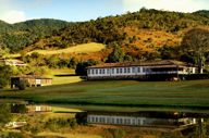 Scenic view of luxury lodge and lake surrounded by rolling hills in Ibitipoca, Minas Gerais, Brazil. 
