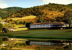 Scenic view of luxury lodge and lake surrounded by rolling hills in Ibitipoca, Minas Gerais, Brazil. 