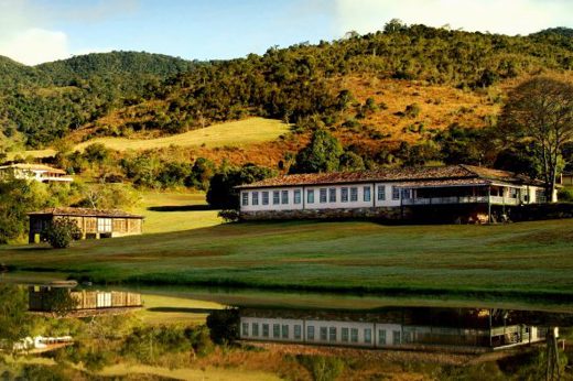 Scenic view of luxury lodge and lake surrounded by rolling hills in Ibitipoca, Minas Gerais, Brazil. 