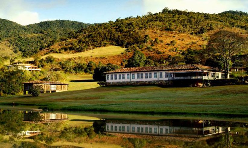 Scenic view of luxury lodge and lake surrounded by rolling hills in Ibitipoca, Minas Gerais, Brazil. 
