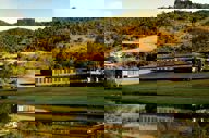 Scenic view of luxury lodge and lake surrounded by rolling hills in Ibitipoca, Minas Gerais, Brazil. 