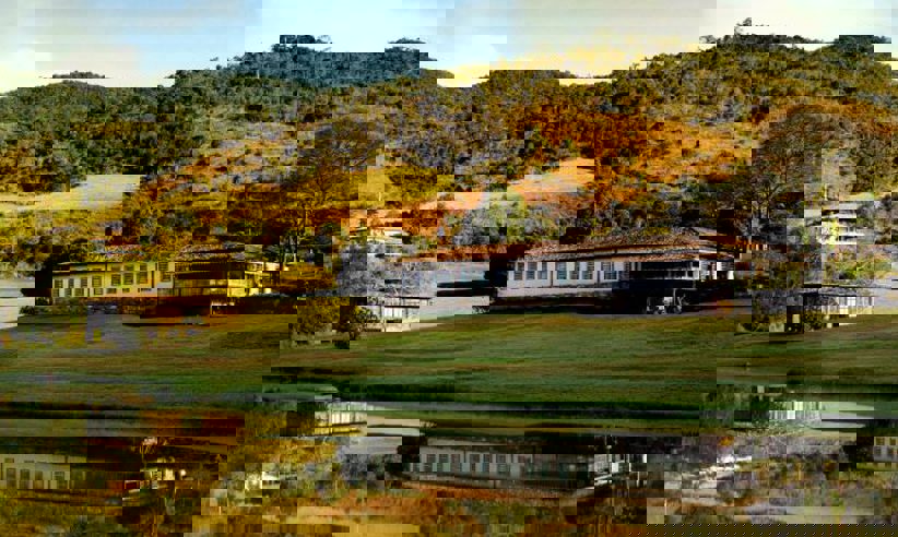 Scenic view of luxury lodge and lake surrounded by rolling hills in Ibitipoca, Minas Gerais, Brazil. 