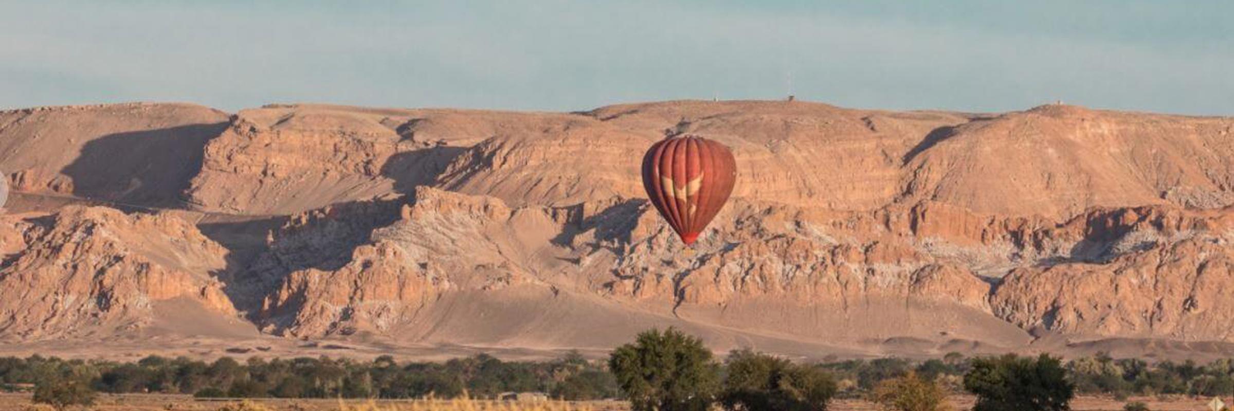 Hot air balloon soaring over the desert landscape of San Pedro de Atacama, offering sweeping views of Chile's arid terrain. 