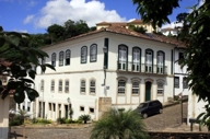 Colonial-style Luxor Ouro Preto Pousada with white facade and arched windows in historic Minas Gerais, Brazil. 