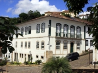 Colonial-style Luxor Ouro Preto Pousada with white facade and arched windows in historic Minas Gerais, Brazil. 